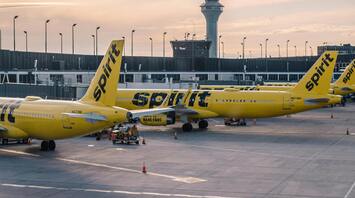 Spirit Airlines airplanes parked at the airport terminal during sunset
