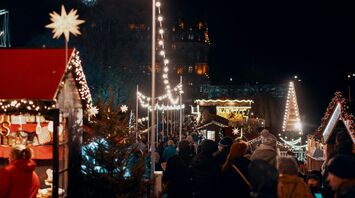 Crowds enjoying festive lights and holiday market stalls in East Scotland during the Christmas season