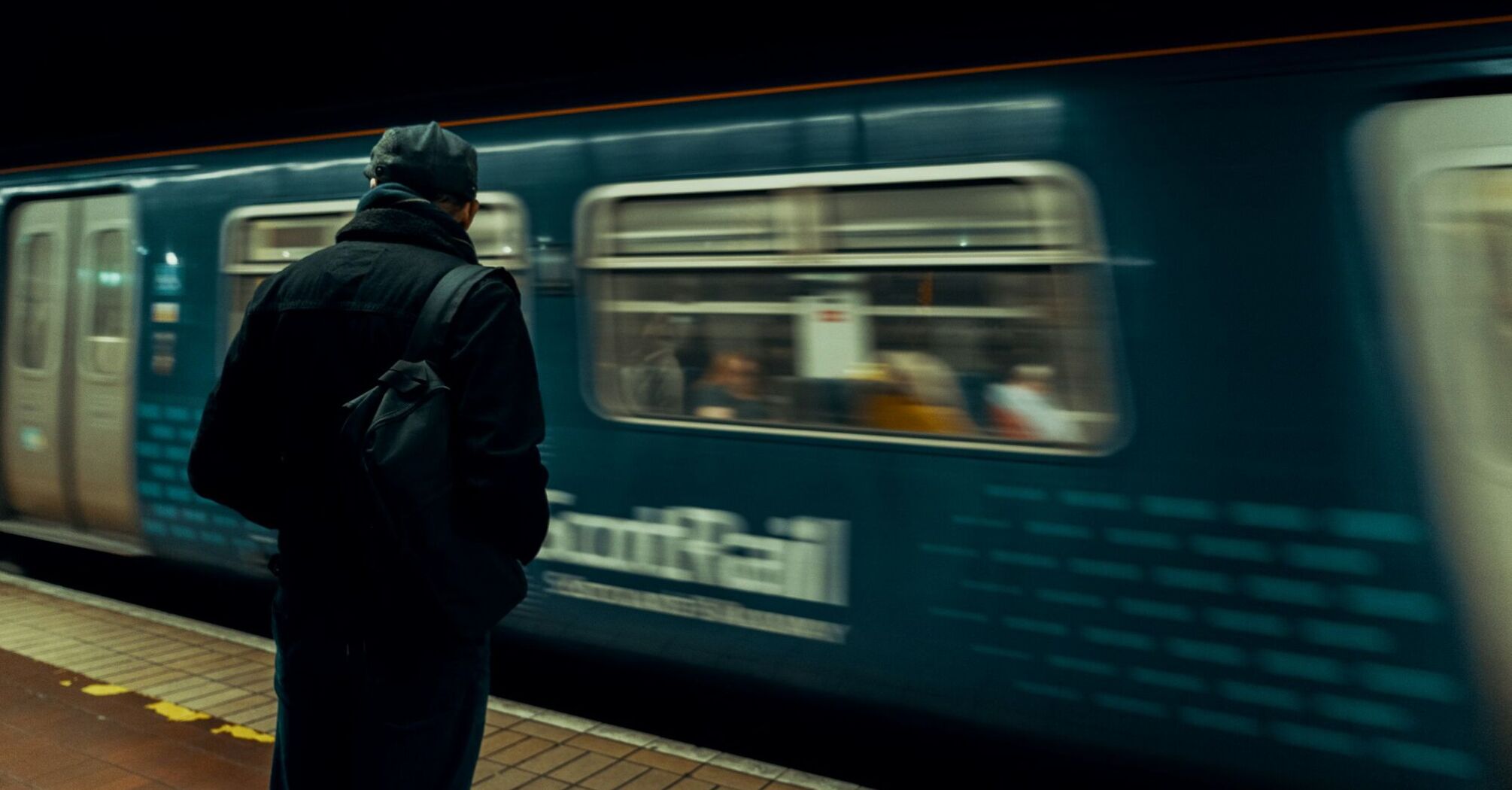 A person waiting on a platform as a ScotRail train speeds by