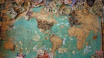 World map with various international currencies and pins marking travel destinations