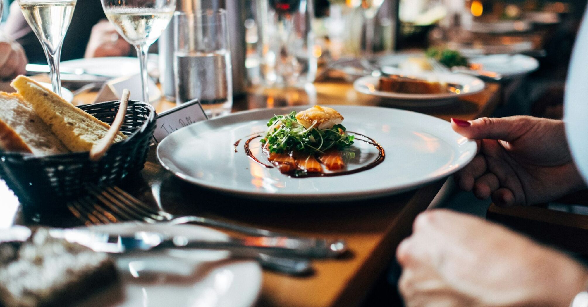 A beautifully presented dish with wine glasses on a restaurant table