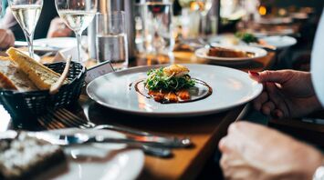 A beautifully presented dish with wine glasses on a restaurant table