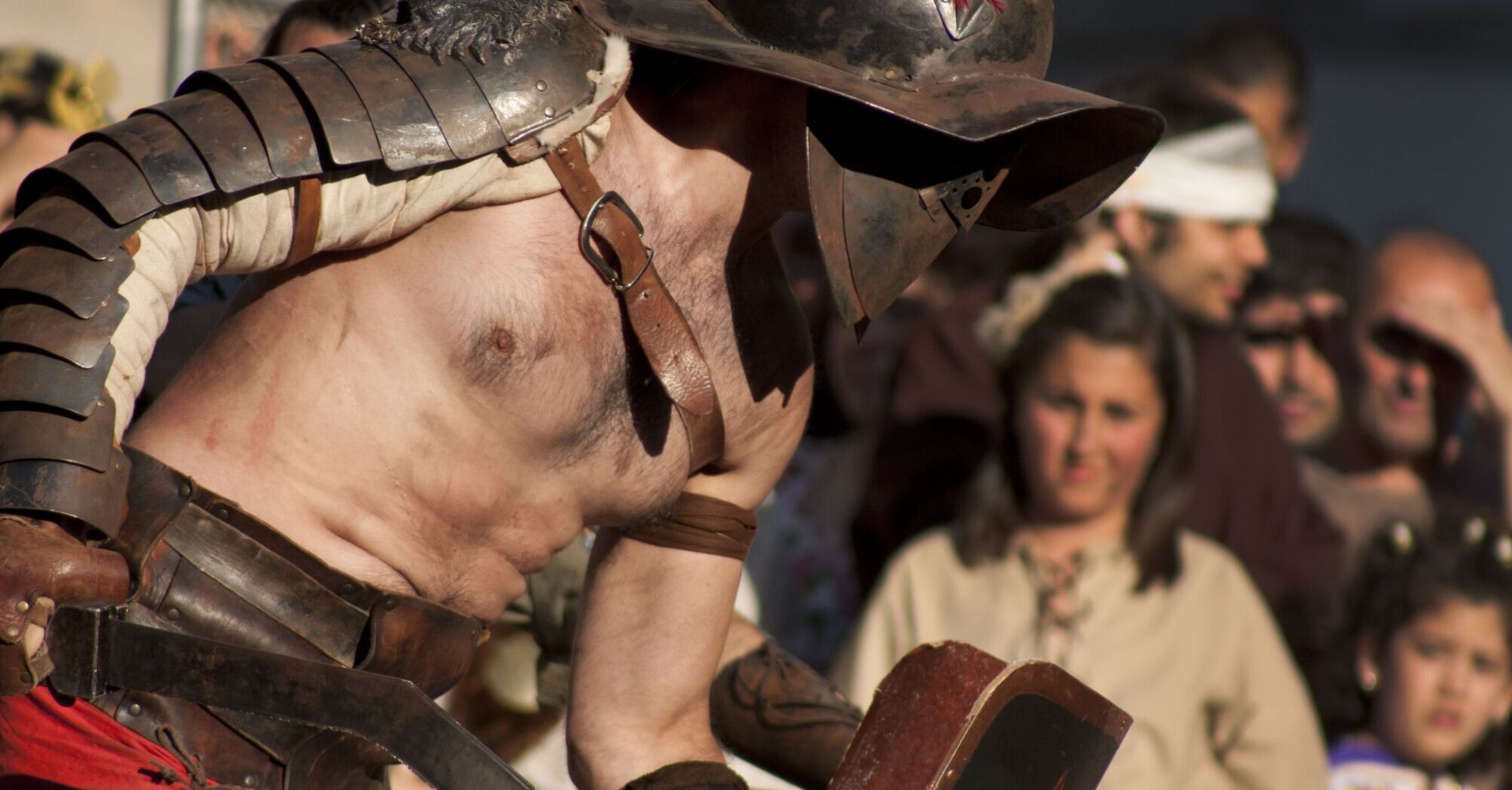 Roman gladiator reenactment with spectators in the background