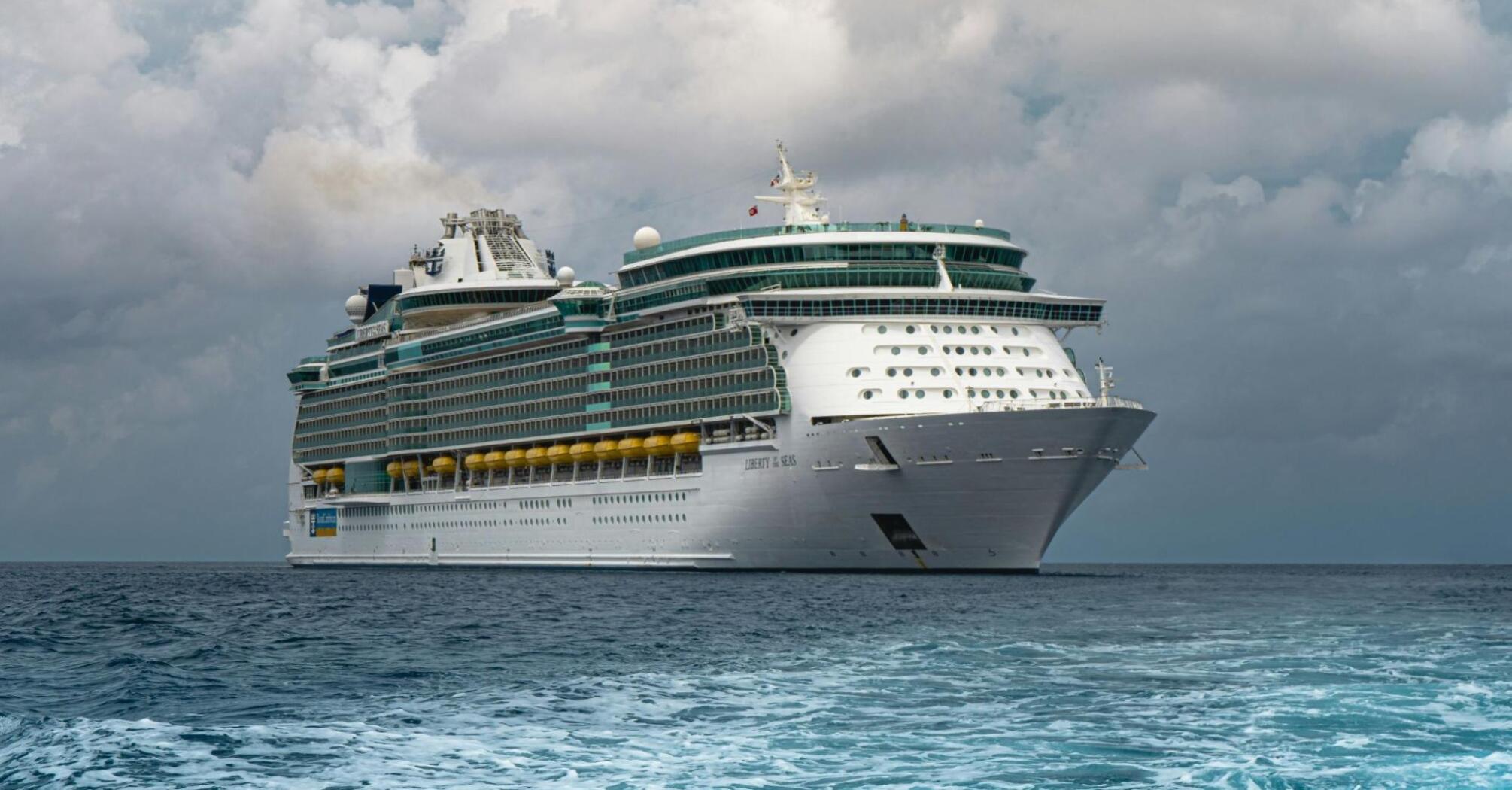 A Royal Caribbean cruise ship sailing in open waters under a cloudy sky