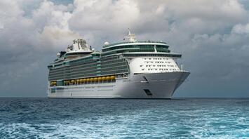 A Royal Caribbean cruise ship sailing in open waters under a cloudy sky