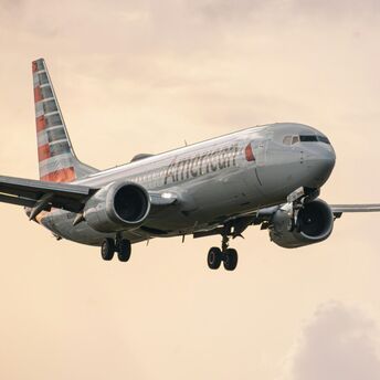 An American Airlines plane landing under a cloudy sky