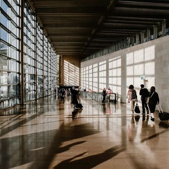 Travelers walking through a bright airport terminal