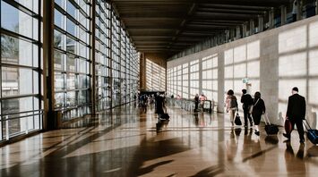 Travelers walking through a bright airport terminal