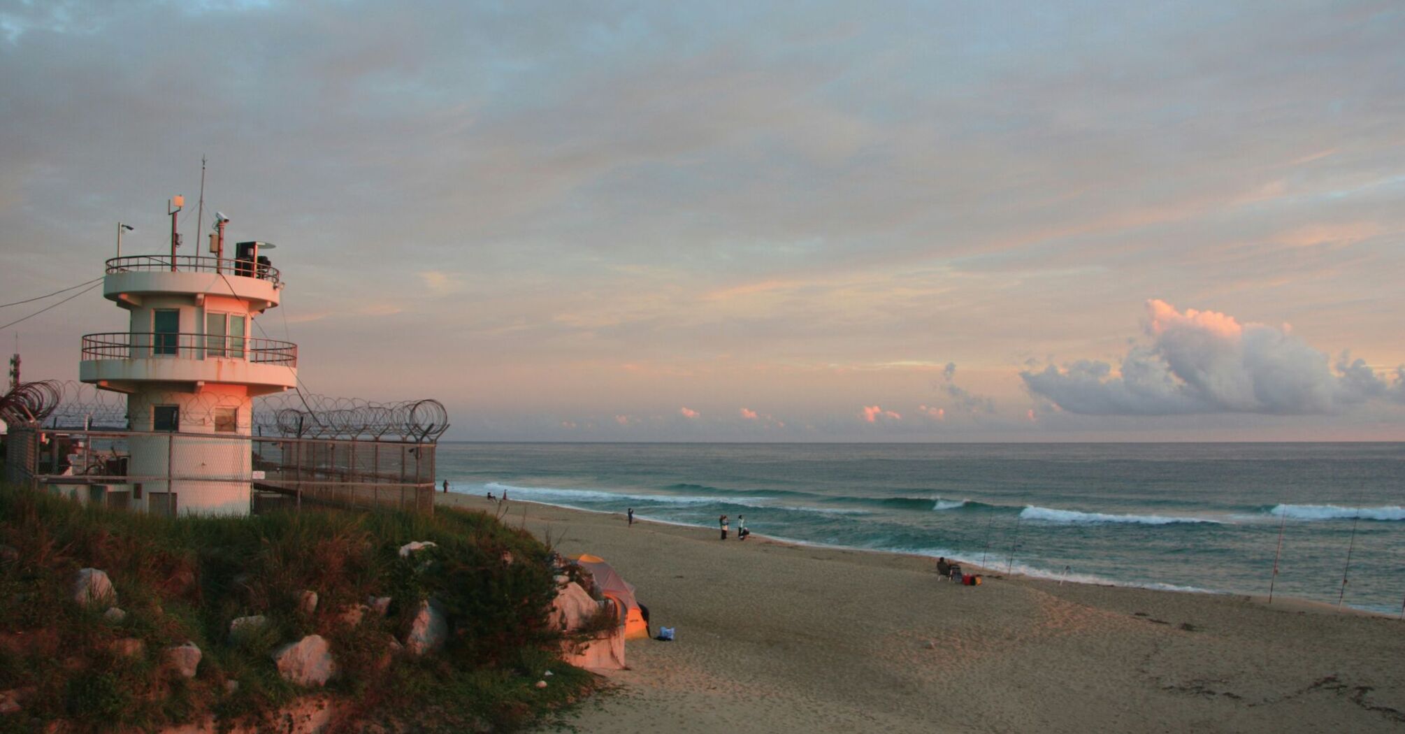 a lifeguard tower on a beach at sunset