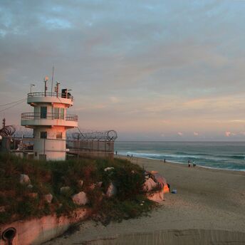 a lifeguard tower on a beach at sunset