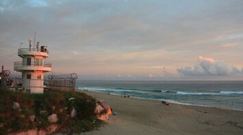 a lifeguard tower on a beach at sunset