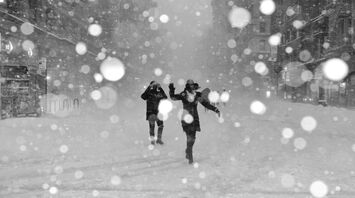 People walking through a snowstorm on a city street