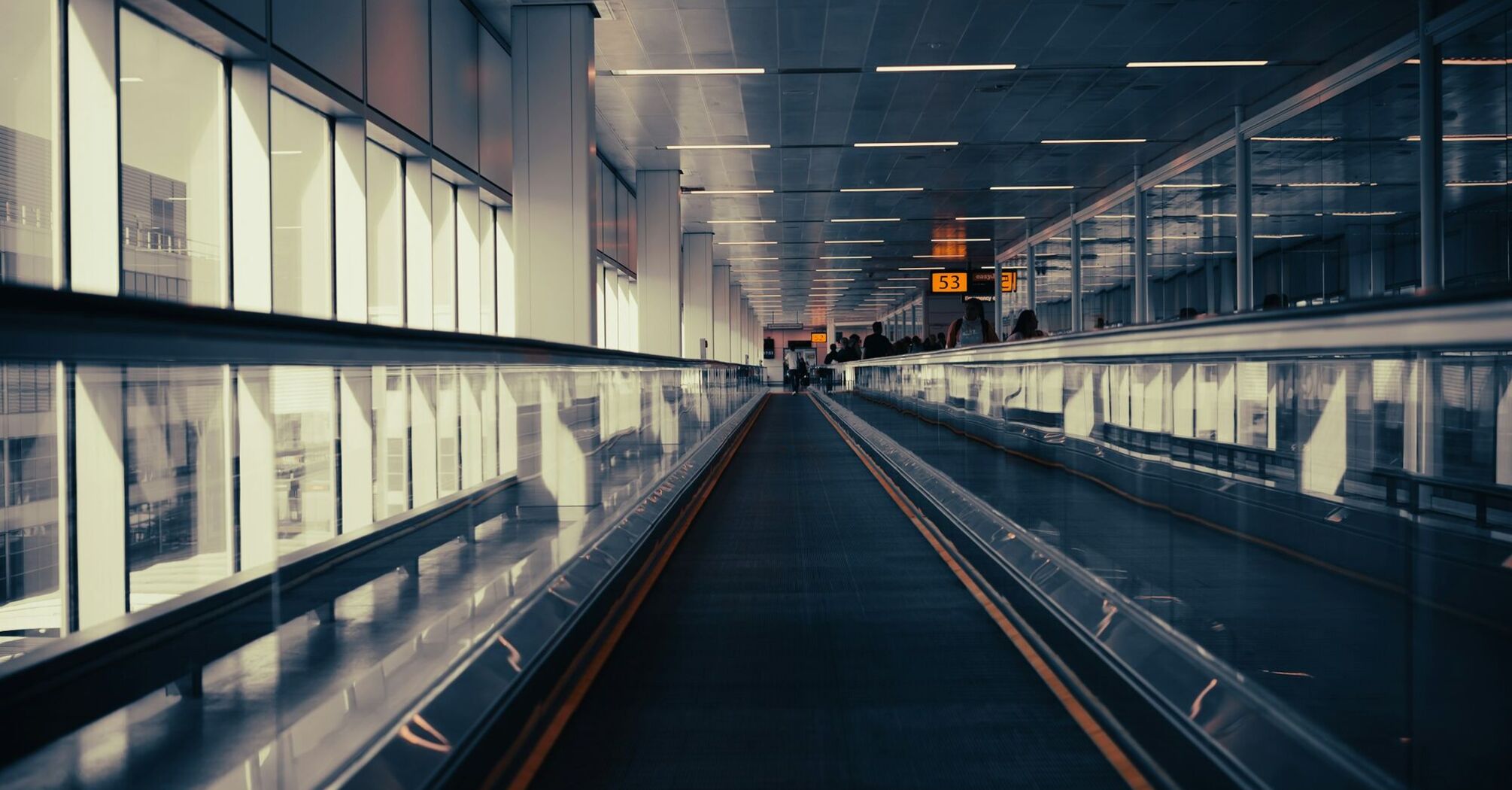 Empty airport walkway under artificial lighting