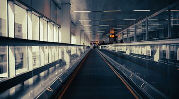 Empty airport walkway under artificial lighting