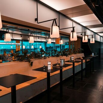 A modern lounge at Vienna Airport with hanging lights and stylish seating arrangements