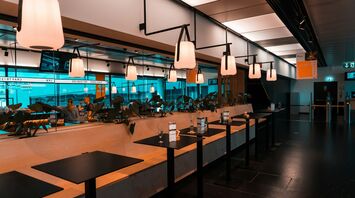 A modern lounge at Vienna Airport with hanging lights and stylish seating arrangements