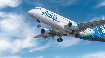 Alaska Airlines plane in flight under a blue sky