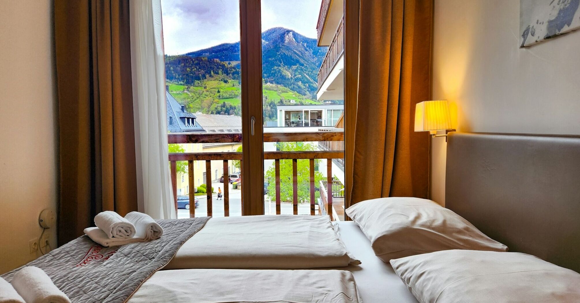 Cozy bedroom with a scenic mountain view through a large wooden-framed window