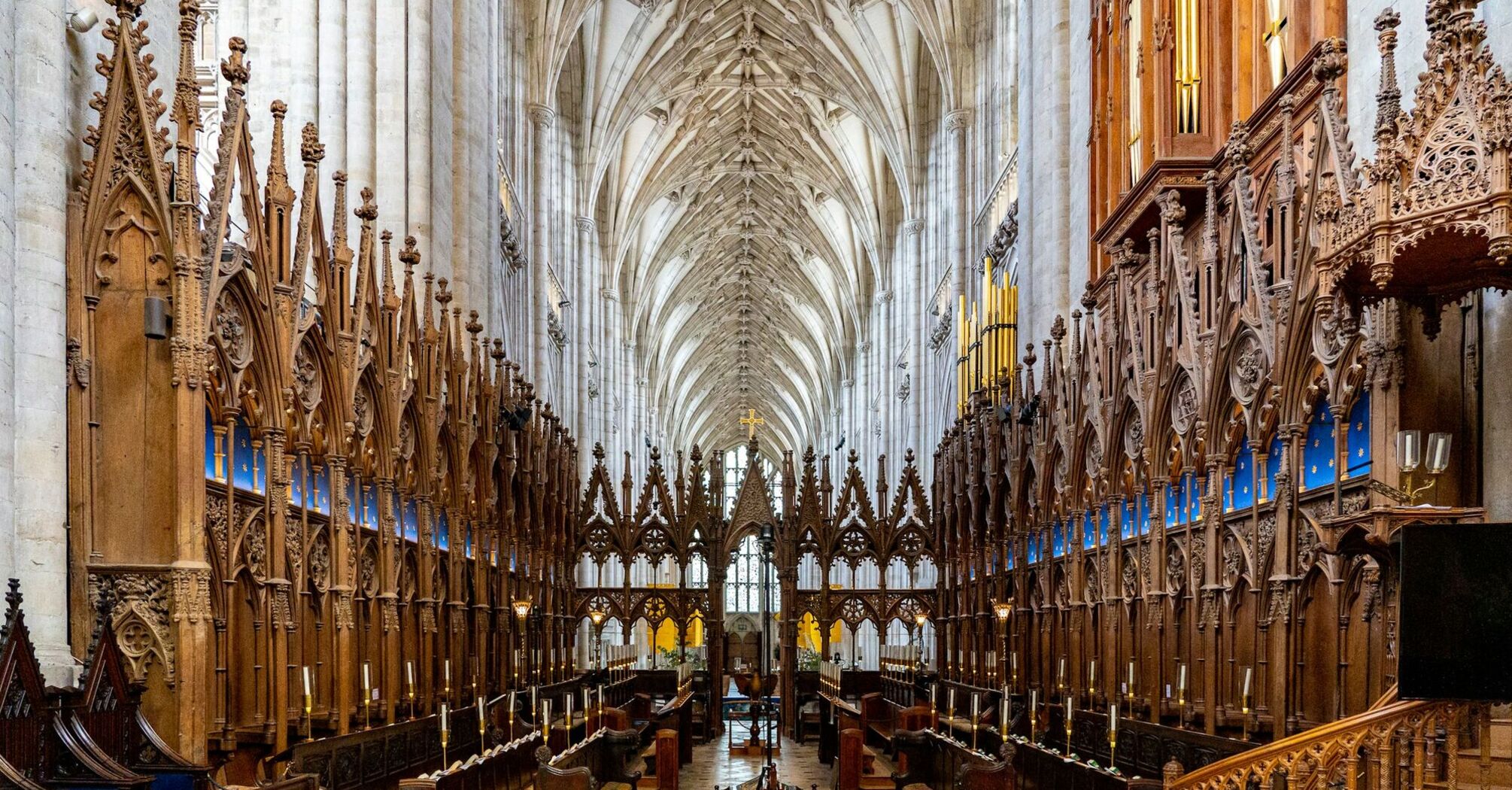 Intricate interior view of Winchester Cathedral with vaulted ceilings and ornate wooden carvings