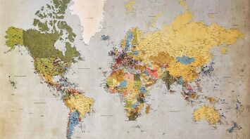 A vintage world map with colorful pins marking various global destinations