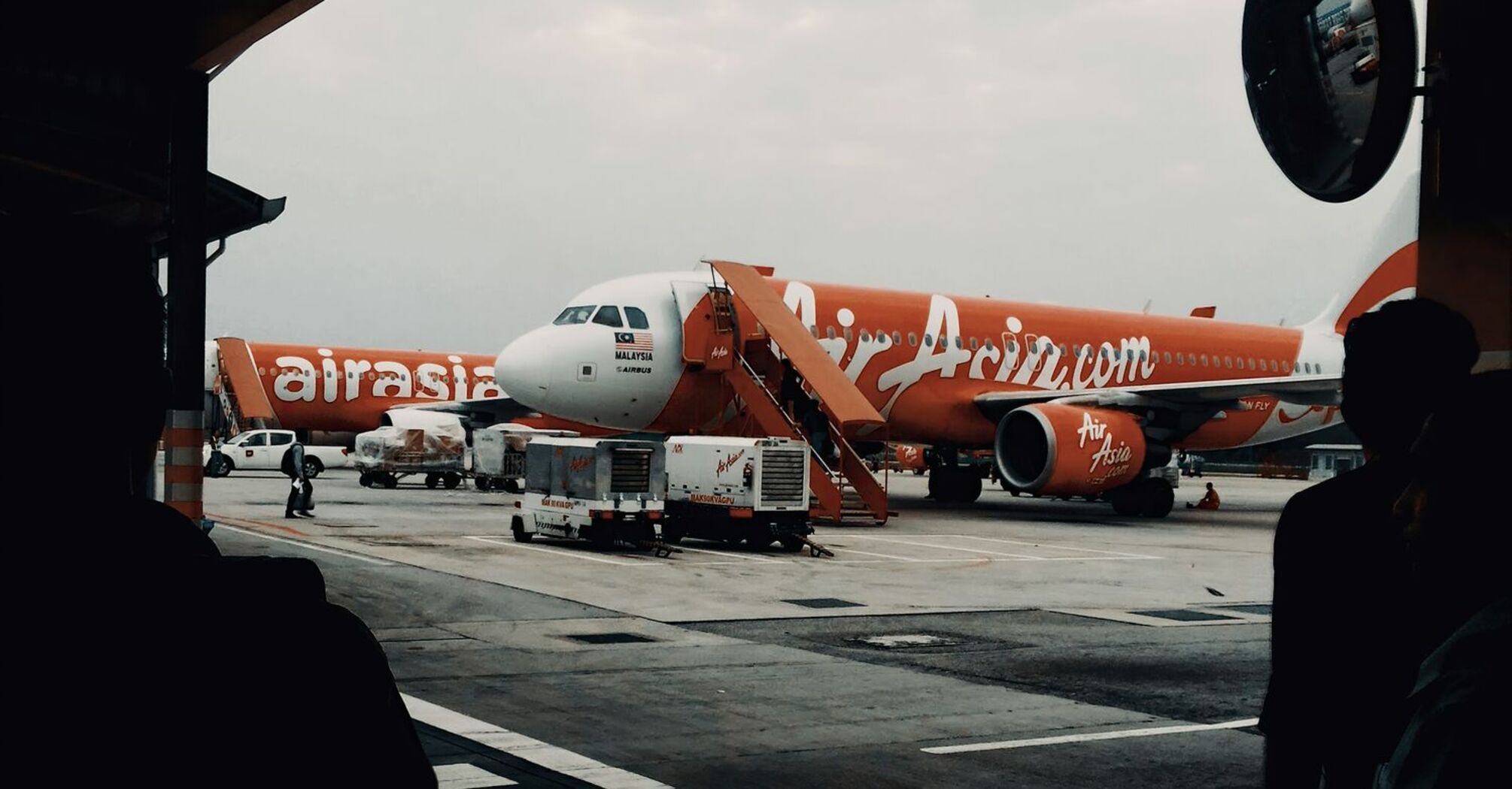 AirAsia aircraft parked at an airport gate during overcast weather