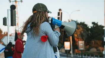 Protester speaking through a megaphone on a city street during a demonstration