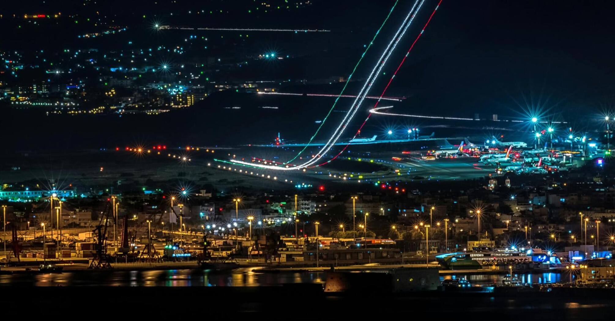 Night view of a bustling airport with departing and parked planes