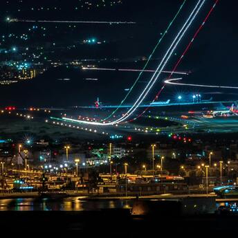 Night view of a bustling airport with departing and parked planes