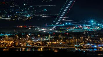 Night view of a bustling airport with departing and parked planes