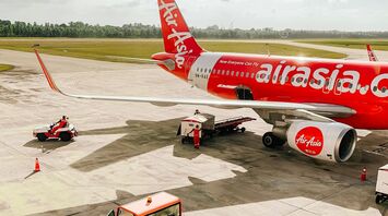 AirAsia X airplane on the tarmac with ground support vehicles