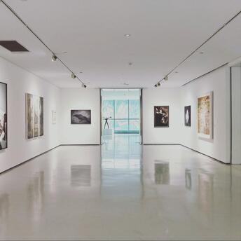 Modern art gallery with framed paintings on white walls