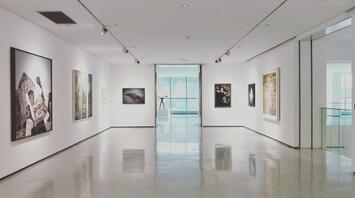 Modern art gallery with framed paintings on white walls