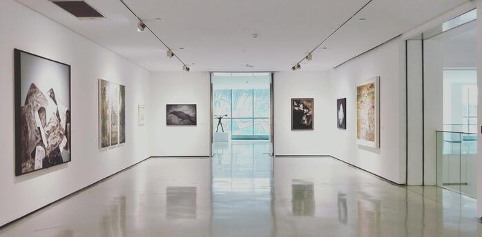 Modern art gallery with framed paintings on white walls