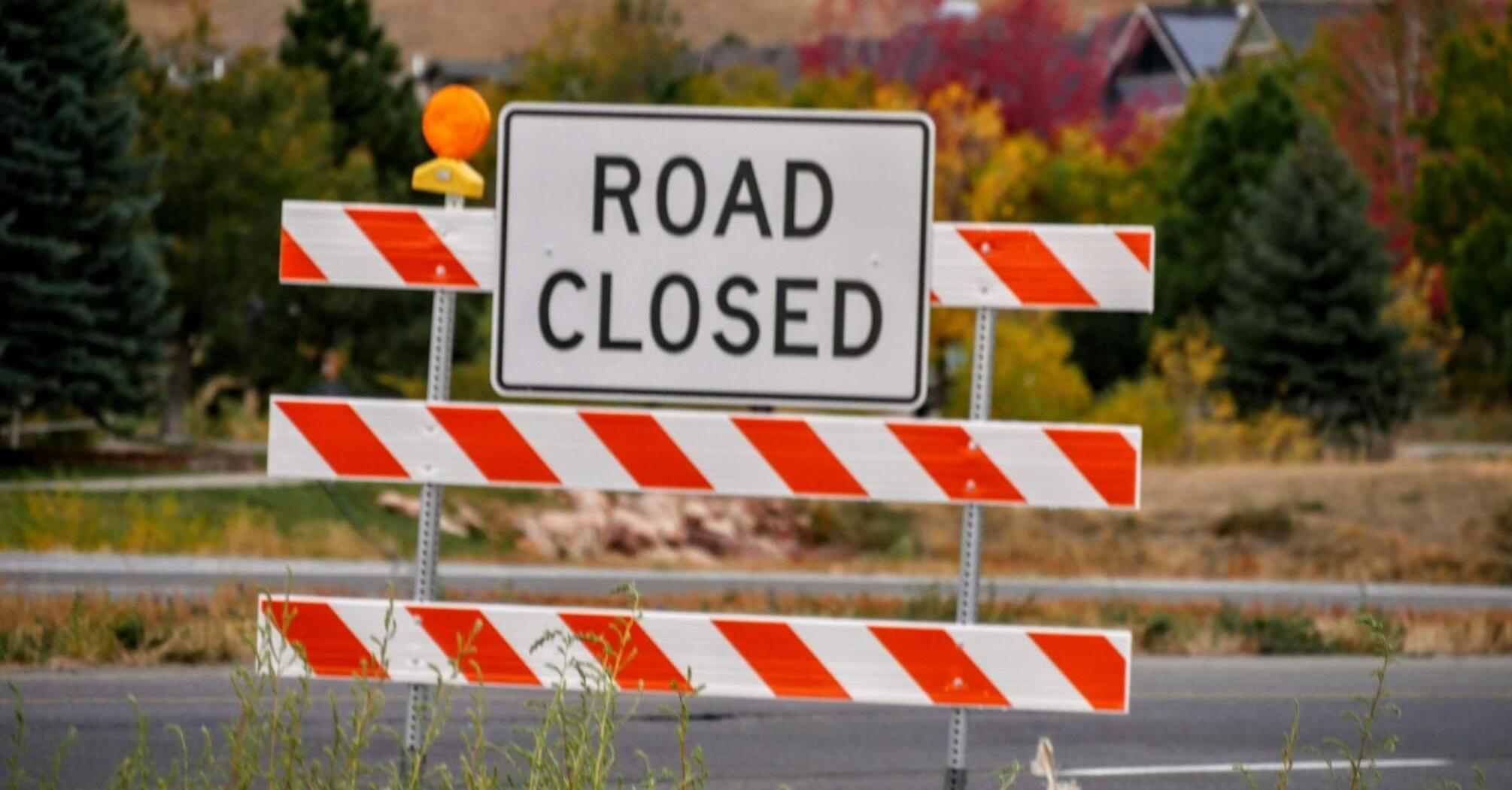 Road closed sign with autumn trees in the background