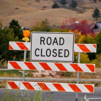 Road closed sign with autumn trees in the background