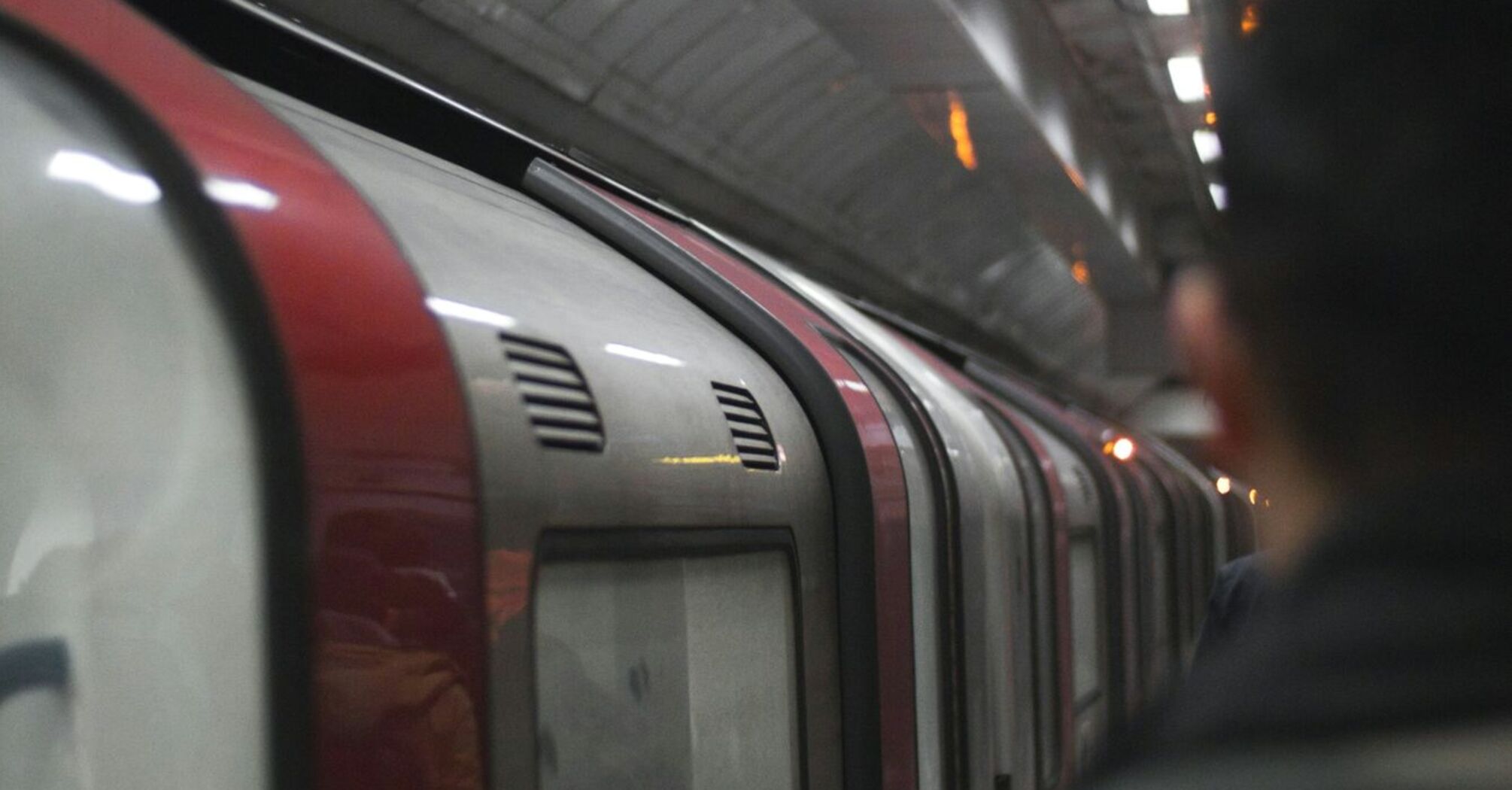 A commuter standing on a London Underground platform beside a train