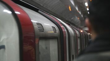 A commuter standing on a London Underground platform beside a train