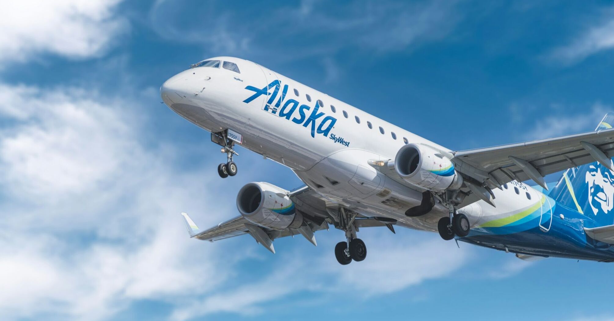 Alaska Airlines plane in flight against a clear blue sky