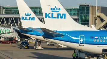 KLM aircraft parked at Amsterdam Airport Schiphol with visible ground services operating nearby