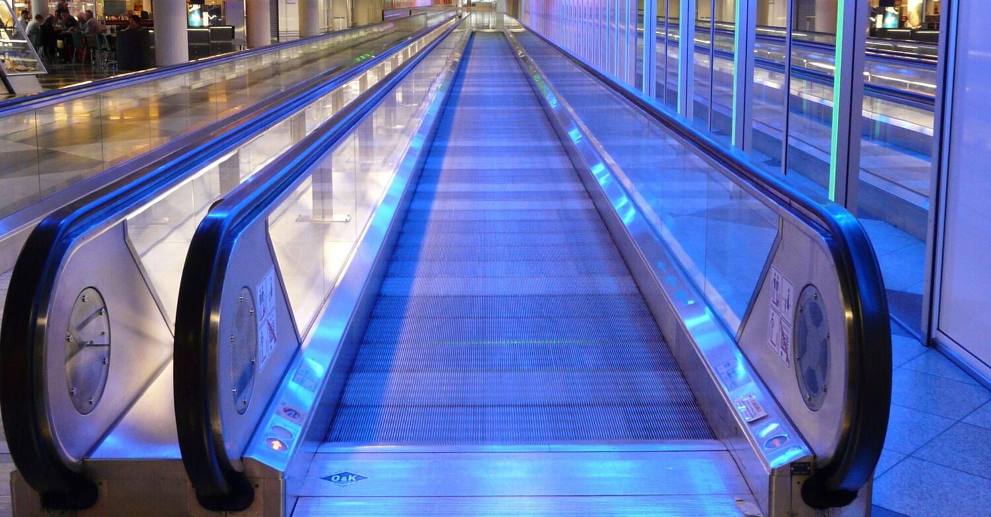 Moving walkway illuminated with blue lights at an airport