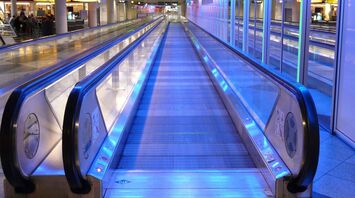 Moving walkway illuminated with blue lights at an airport