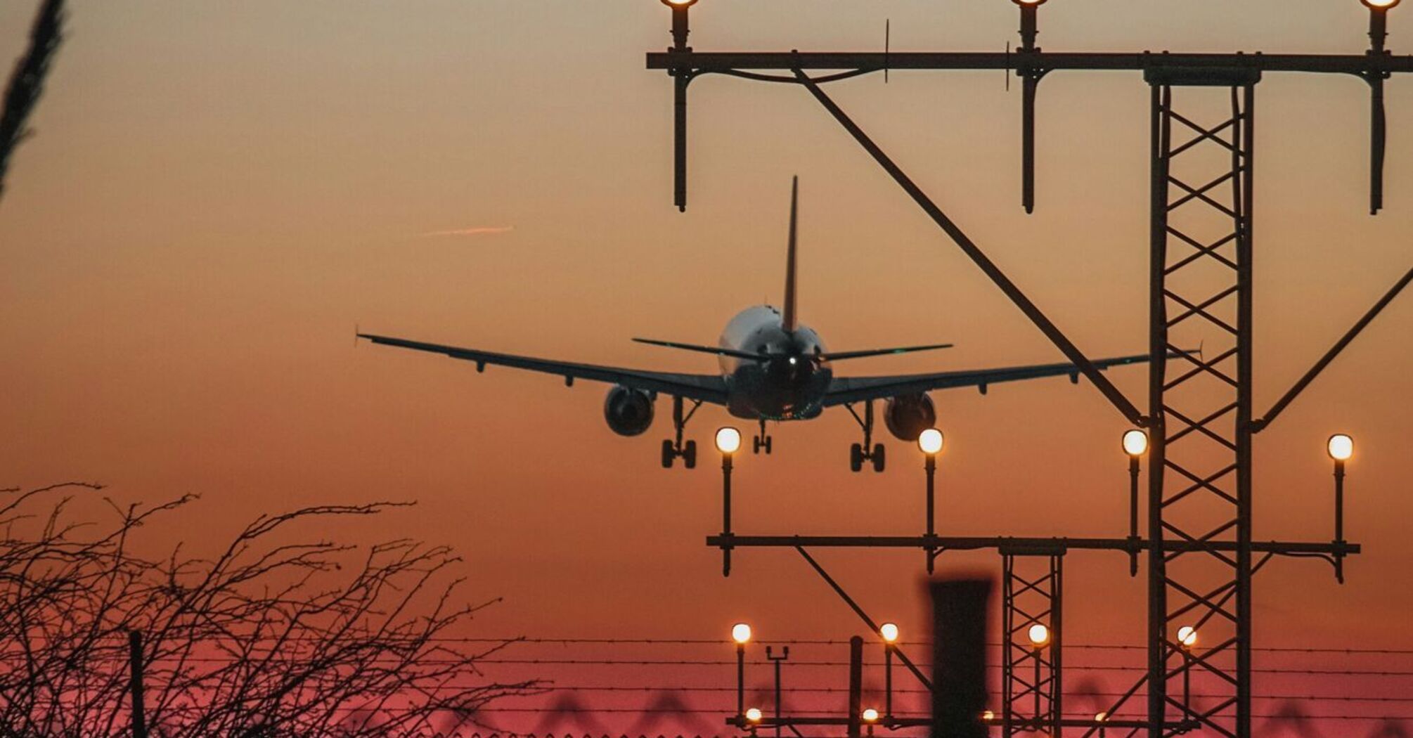 Plane landing at dusk with runway lights