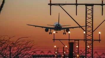 Plane landing at dusk with runway lights