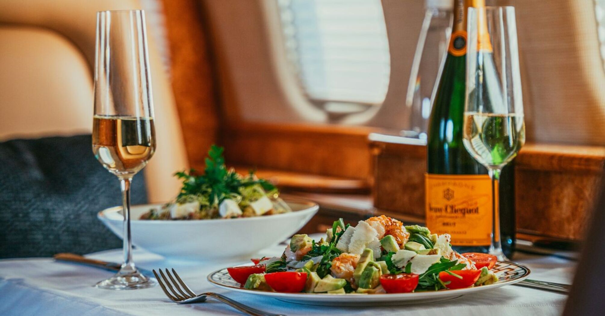 Gourmet meal with champagne served in a luxury airplane cabin