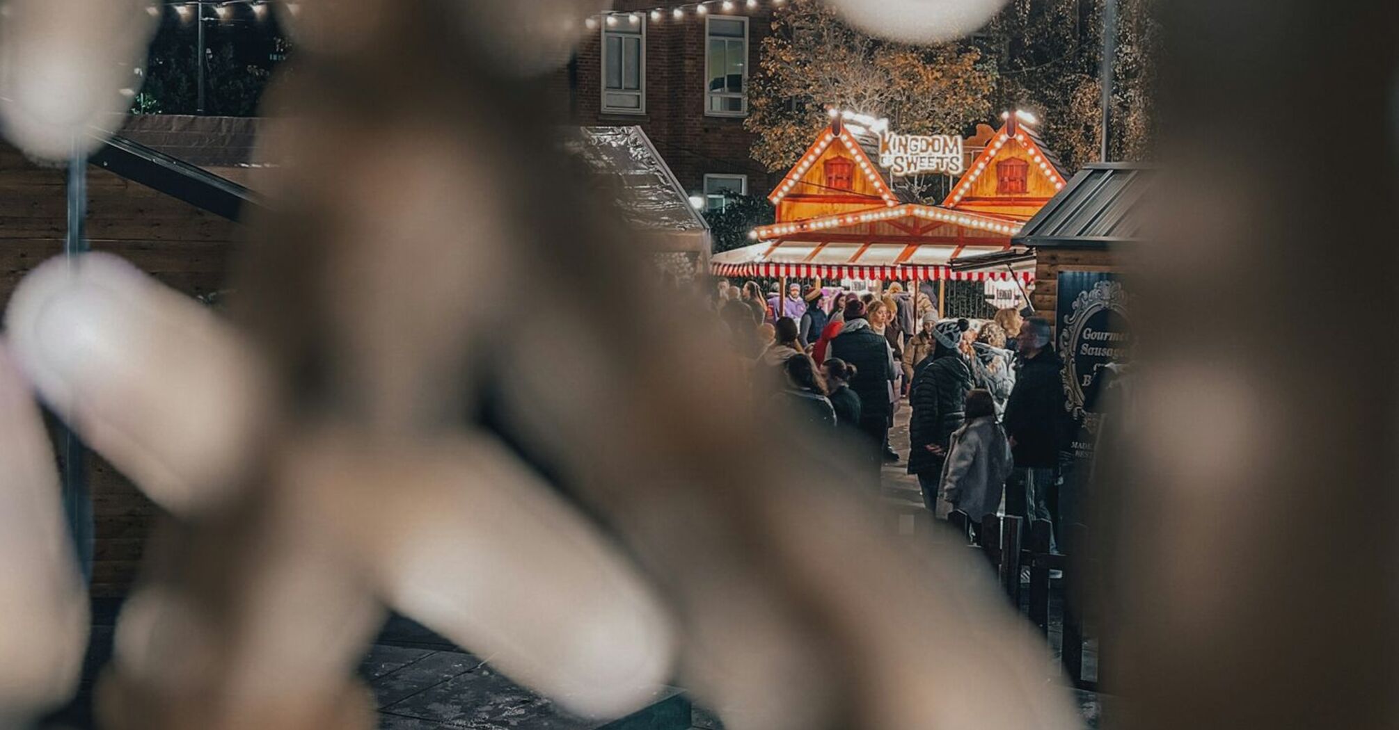 Festive lights and a crowd at a cozy outdoor holiday market