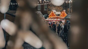 Festive lights and a crowd at a cozy outdoor holiday market