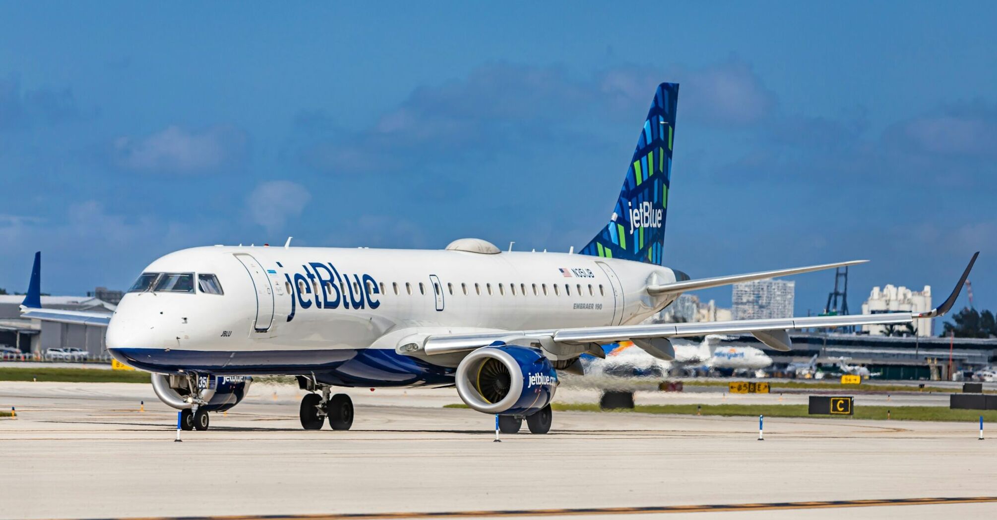 JetBlue Embraer aircraft on runway at an airport