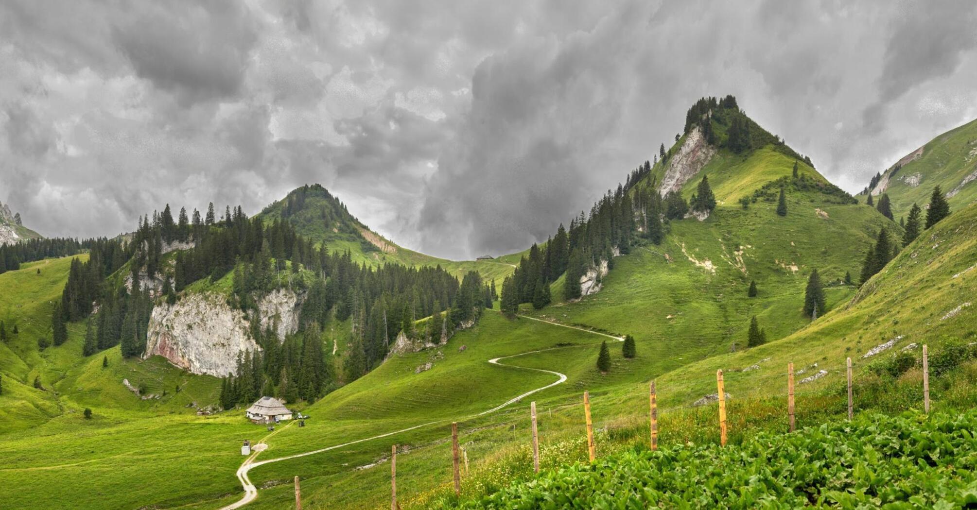 Scenic view of green hills and cloudy sky in a mountainous landscape