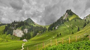 Scenic view of green hills and cloudy sky in a mountainous landscape