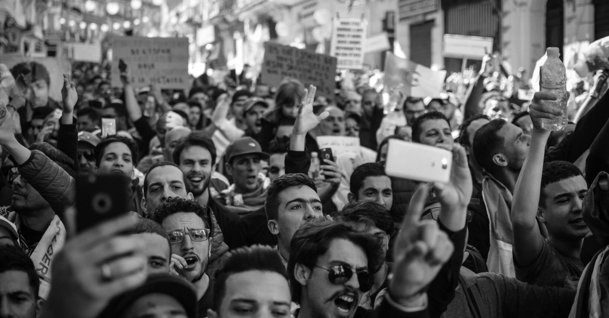 Crowd of protesters raising hands and holding signs